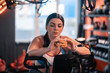 © Viacheslav Yakobchuk - Plump mature woman holding fat burger while cycling in gym