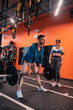 © Viacheslav Yakobchuk - Handsome trainer working out with barbell near his client