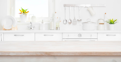 Defocused kitchen room and window with wood table in front