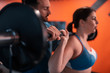 © Viacheslav Yakobchuk - Close up of handsome trainer helping woman with lifting barbell