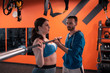 © Viacheslav Yakobchuk - Bearded trainer assisting plump woman with lifting barbell