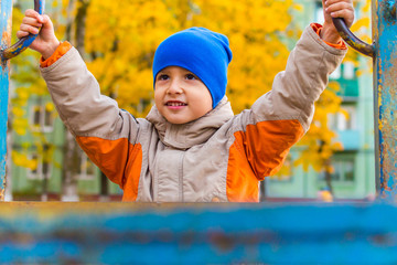 Wall Mural - boy playing on the Playground in autumn