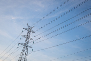 High voltage post tower with blue sky before sunset