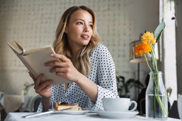 Wall Mural - Beautiful young blonde woman sitting at the cafe