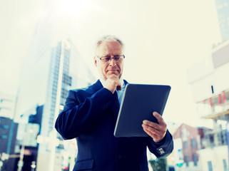 Canvas Print - business, technology and people concept - senior businessman with tablet pc computer on city street