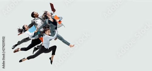 Foto  Happy office workers jumping and dancing in casual clothes or suit with folders isolated on studio background