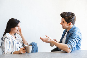 Wall Mural - Attractive young couple drinking coffee