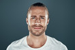 © G-Stock Faces - Feeling displeased. Handsome young man looking at camera while standing against grey background