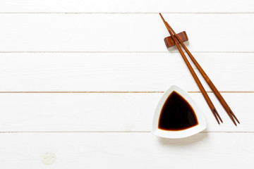 Wall Mural - Soy sauce with chopsticks on white wooden table background