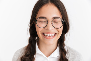 Wall Mural - Portrait closeup of happy teenage girl wearing eyeglasses and school uniform laughing with eyes closed