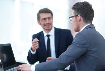 close up.business partners talk sitting at a Desk