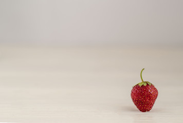 Fresh summer ripe strawberry berry isolated close-up on white wooden background, copy space