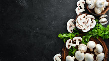 Mushrooms Sliced On A Black Table Surface. Top View. Free Space For Text.