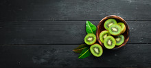 Fresh Kiwi And Green Leaves On The Table. Rustic Style. Fruits. Top View. Free Space For Text.