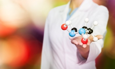 Wall Mural - Close up of Molecular structure model in hand on background