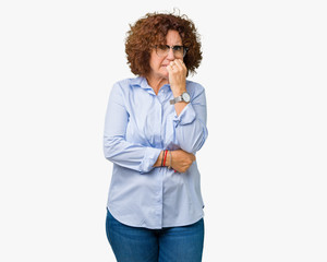 Beautiful middle ager senior businees woman wearing glasses over isolated background looking stressed and nervous with hands on mouth biting nails. Anxiety problem.