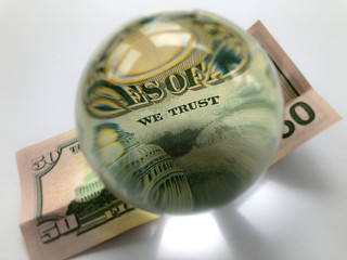 US $50 banknote with a crystal ball. Selective focus on the words We Trust. Creative concept, business and banking