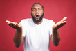© denis_vermenko - Closeup portrait of dumb clueless young african man, arms out asking why what's the problem, I don't know. Isolated on red background. Negative human emotion facial expression feelings
