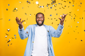 winner! cheerful african american young man dancing over yellow background.