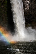 A Man Paddles Around The Base Of The Massive Palouse Falls On A Sunny Spring Day.