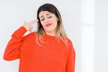 Canvas Print - Young woman wearing casual red sweater over isolated background Shooting and killing oneself pointing hand and fingers to head, suicide gesture.