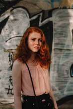 Portrait Of Young Confident  Woman Standing Against Wall In City