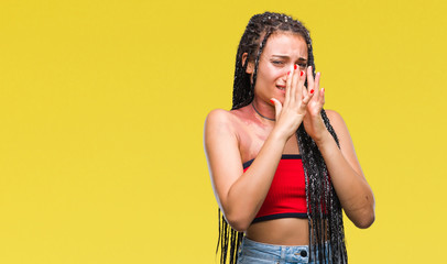 Wall Mural - Young braided hair african american with pigmentation blemish birth mark over isolated background smelling something stinky and disgusting, intolerable smell, holding breath with fingers on nose