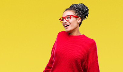 Sticker - Young braided hair african american girl wearing sweater and glasses over isolated background looking away to side with smile on face, natural expression. Laughing confident.