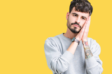 Poster - Young handsome man wearing sweatshirt over isolated background sleeping tired dreaming and posing with hands together while smiling with closed eyes.