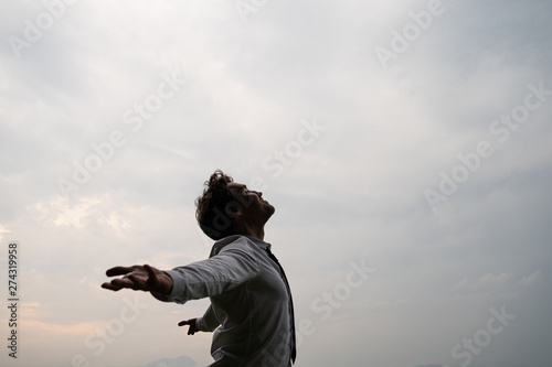 Fotografía Peaceful young businessman standing with his arms spread