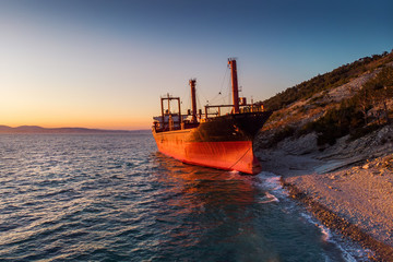 Aerial view of ship run aground on sea coast, shipwreck after storm