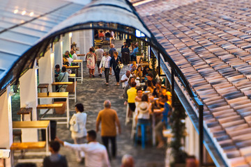 DENIA, SPAIN - JUNE 13, 2019: People eating and drinking at Els Magazinos market in Denia town.