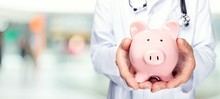 Male Doctor Holding Piggy Bank