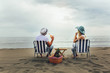 © Mediteraneo - Couple on a deck chair relaxing on the beach. Happy couple enjoy on the beach during summer vacations