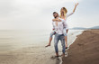 © Mediteraneo - Happy couple in love on beach summer vacations. Joyful girl piggybacking on young boyfriend having fun.