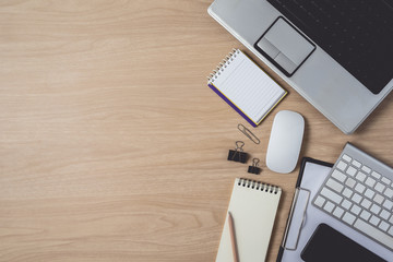 Workspace with diary or notebook and clipboard, laptop, mouse computer, keyboard, smart phone, pencil, pen on wooden background