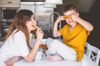 © Alena Ozerova - Pregnant mom with kid eating bagels together in the kitchen
