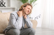 © Pixel-Shot - Young man suffering from neck pain at home