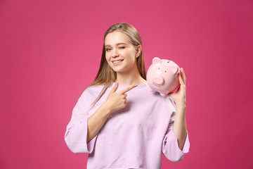 Sticker - Happy woman with piggy bank on color background