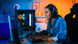 © Gorodenkoff - Pretty and Excited Black Gamer Girl in Headphones is Playing First-Person Shooter Online Video Game on Her Computer. Room and PC have Colorful Neon Led Lights. Cozy Evening at Home.