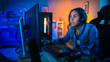 © Gorodenkoff - Pretty and Excited Black Gamer Girl Has a Tense Moment in Her First-Person Online Shooter Video Game on Her Computer. Room and PC have Colorful Neon Led Lights. Cozy Evening at Home.