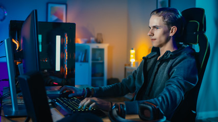 Wall Mural - Concentrated Gamer Playing First-Person Shooter Online Video Game on His Powerful Personal Computer. Room and PC have Colorful Neon Led Lights. Cozy Evening at Home.