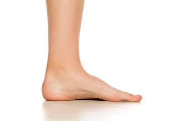 side view of female bare foot on white background