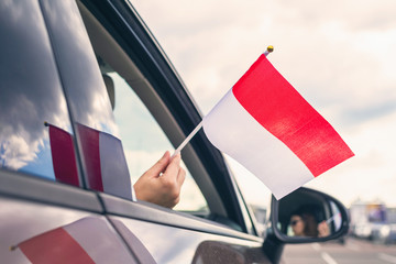 Wall Mural - Woman or Girl Holding Indonesia Flag from the open car window