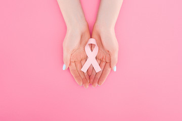 Wall Mural - partial view of woman with pink breast cancer sign on pink background