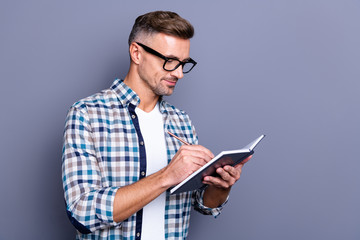 Wall Mural - Close up photo handsome he him his guy hands arms hold notebook making notes author have inspiration clever smart creative ideas wear specs casual plaid checkered shirt isolated grey background