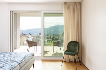 Modern bedroom with bed and velvet chair