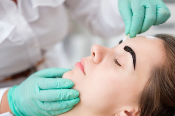 Beautician performing henna brows correction