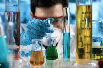 Wall Mural - hand of Chemical engineer pipetting samples with syringe pipette in the research laboratory