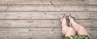 Top view of woman legs barefoot with handmade leather sandals on rustic wooden background. Female feet with colored nails and summer footwear. Vacation, holiday, freedom, relax and carefree concept.
